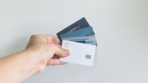 Photo of a hand holding credit and debit cards.